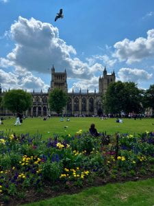 A photo of Bristol Cathedral with students relaxing on the lawns in front of it.